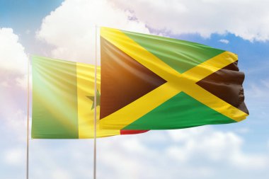 Sunny blue sky and flags of jamaica and senegal