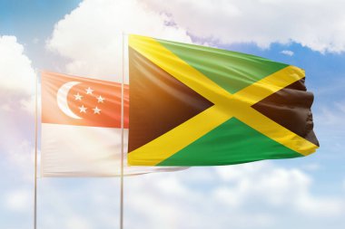 Sunny blue sky and flags of jamaica and singapore