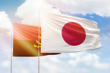 Sunny blue sky and flags of japan and angola