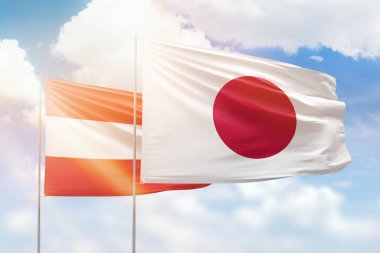 Sunny blue sky and flags of japan and austria