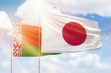 Sunny blue sky and flags of japan and belarus