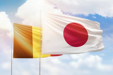 Sunny blue sky and flags of japan and belgium