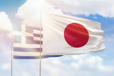 Sunny blue sky and flags of japan and greece
