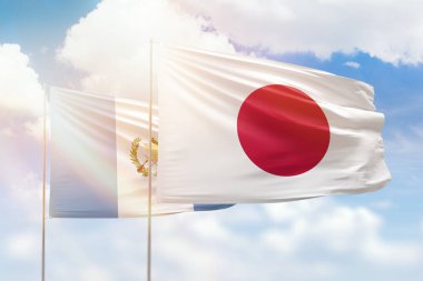 Sunny blue sky and flags of japan and guatemala