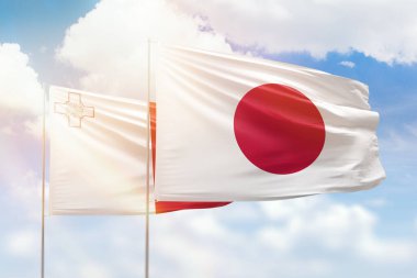 Sunny blue sky and flags of japan and malta