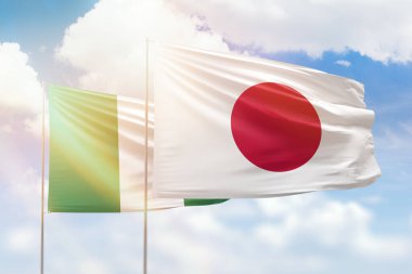 Sunny blue sky and flags of japan and nigeria