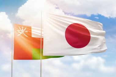Sunny blue sky and flags of japan and oman