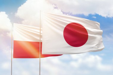 Sunny blue sky and flags of japan and poland