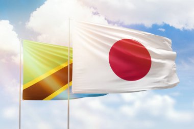 Sunny blue sky and flags of japan and tanzania