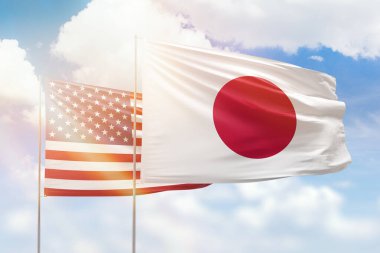 Sunny blue sky and flags of japan and usa