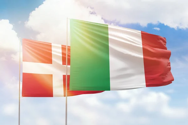 Sunny blue sky and flags of italy and denmark