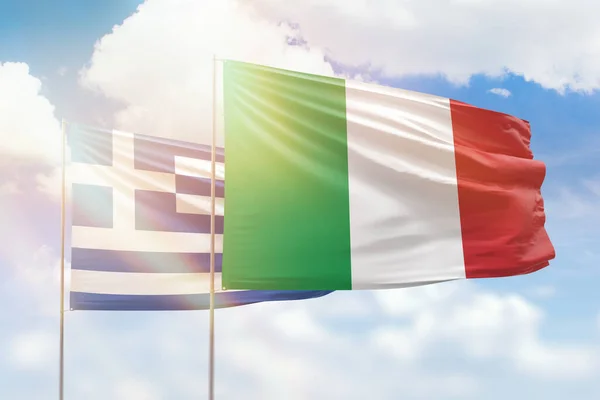 Sunny blue sky and flags of italy and greece