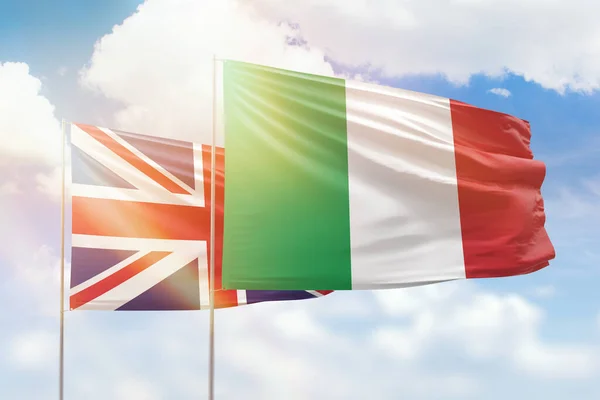 Sunny blue sky and flags of italy and united kingdom
