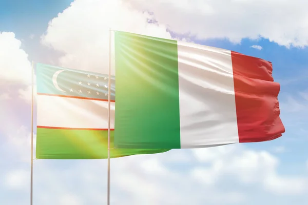 Sunny blue sky and flags of italy and uzbekistan