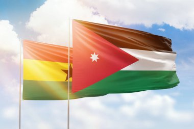 Sunny blue sky and flags of jordan and ghana