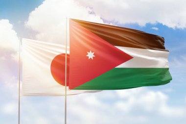 Sunny blue sky and flags of jordan and japan