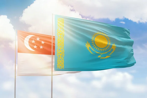 Sunny blue sky and flags of kazakhstan and singapore