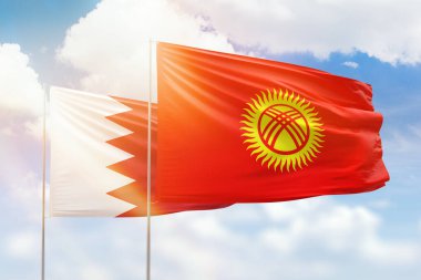 Sunny blue sky and flags of kyrgyzstan and bahrain