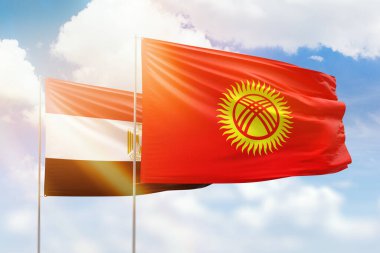 Sunny blue sky and flags of kyrgyzstan and egypt
