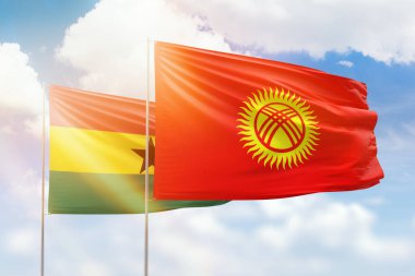 Sunny blue sky and flags of kyrgyzstan and ghana