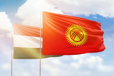 Sunny blue sky and flags of kyrgyzstan and hungary