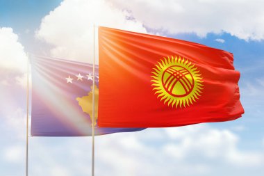 Güneşli mavi gökyüzü ve Kırgızistan ve Kosova bayrakları. Tarihi bayrak