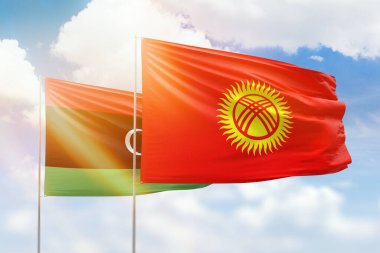 Sunny blue sky and flags of kyrgyzstan and libya