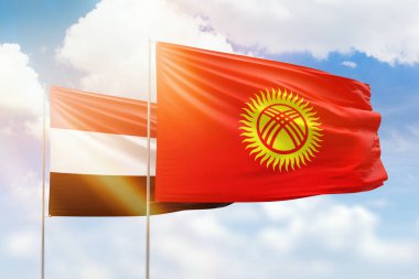 Sunny blue sky and flags of kyrgyzstan and yemen