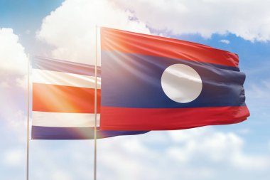 Sunny blue sky and flags of laos and costa rica