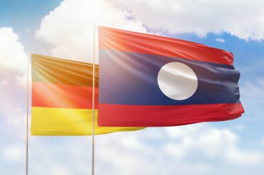 Sunny blue sky and flags of laos and germany