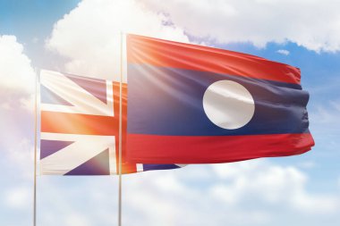Sunny blue sky and flags of laos and great britain