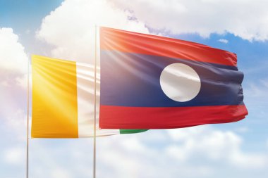 Sunny blue sky and flags of laos and ivory coast