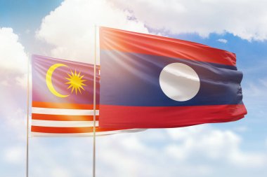 Sunny blue sky and flags of laos and malaysia