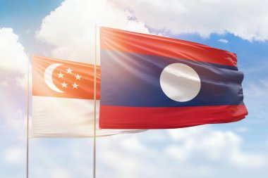 Sunny blue sky and flags of laos and singapore