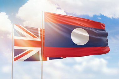 Sunny blue sky and flags of laos and united kingdom