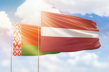 Sunny blue sky and flags of latvia and belarus