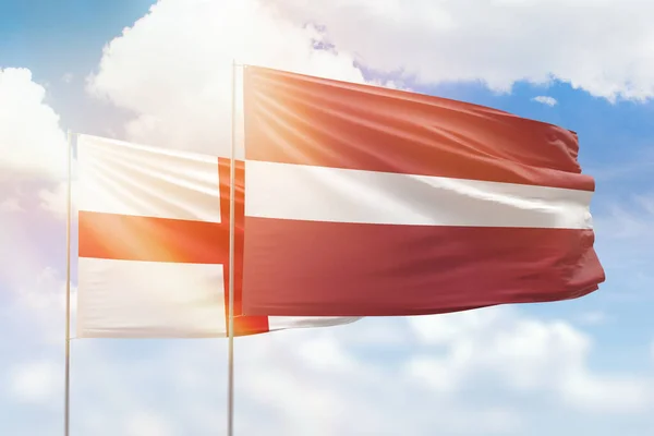 Sunny Blue Sky Flags Latvia England – stockfoto