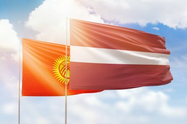 Sunny blue sky and flags of latvia and kyrgyzstan