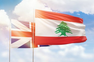 Sunny blue sky and flags of lebanon and great britain