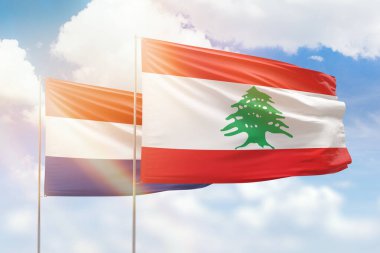 Sunny blue sky and flags of lebanon and netherlands