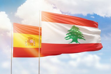 Sunny blue sky and flags of lebanon and spain
