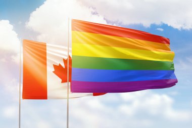 Sunny blue sky and flags of lgbt and canada