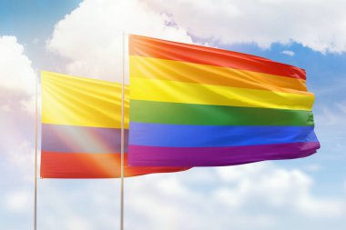 Sunny blue sky and flags of lgbt and colombia