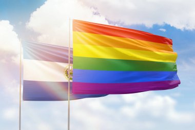 Sunny blue sky and flags of lgbt and el salvador
