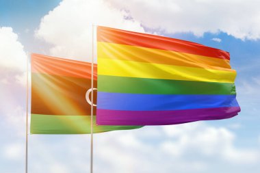 Sunny blue sky and flags of lgbt and libya