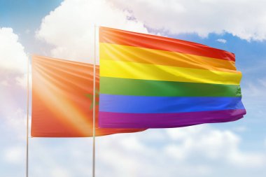 Sunny blue sky and flags of lgbt and morocco