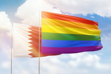 Sunny blue sky and flags of lgbt and qatar