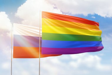 Sunny blue sky and flags of lgbt and russia