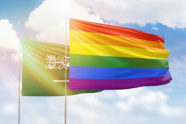Sunny blue sky and flags of lgbt and saudi arabia