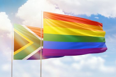 Sunny blue sky and flags of lgbt and south africa